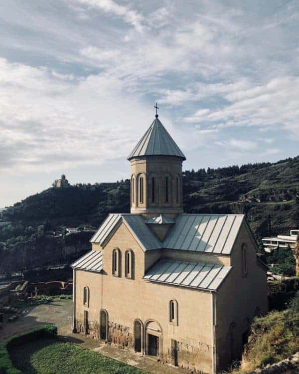 An old church with a steeple perched on a hillside