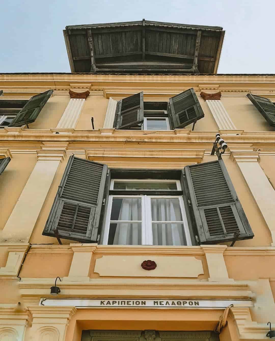 A city museum building with decorative shutters and a sign