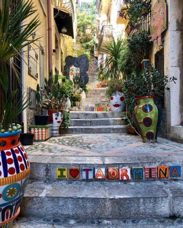 A vibrant street scene featuring colorful pots and vases adorning the steps