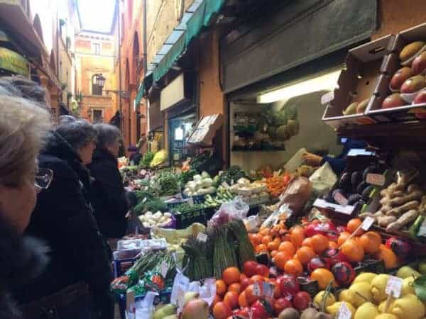 Shoppers browsing colorful fruits and vegetables at a lively market