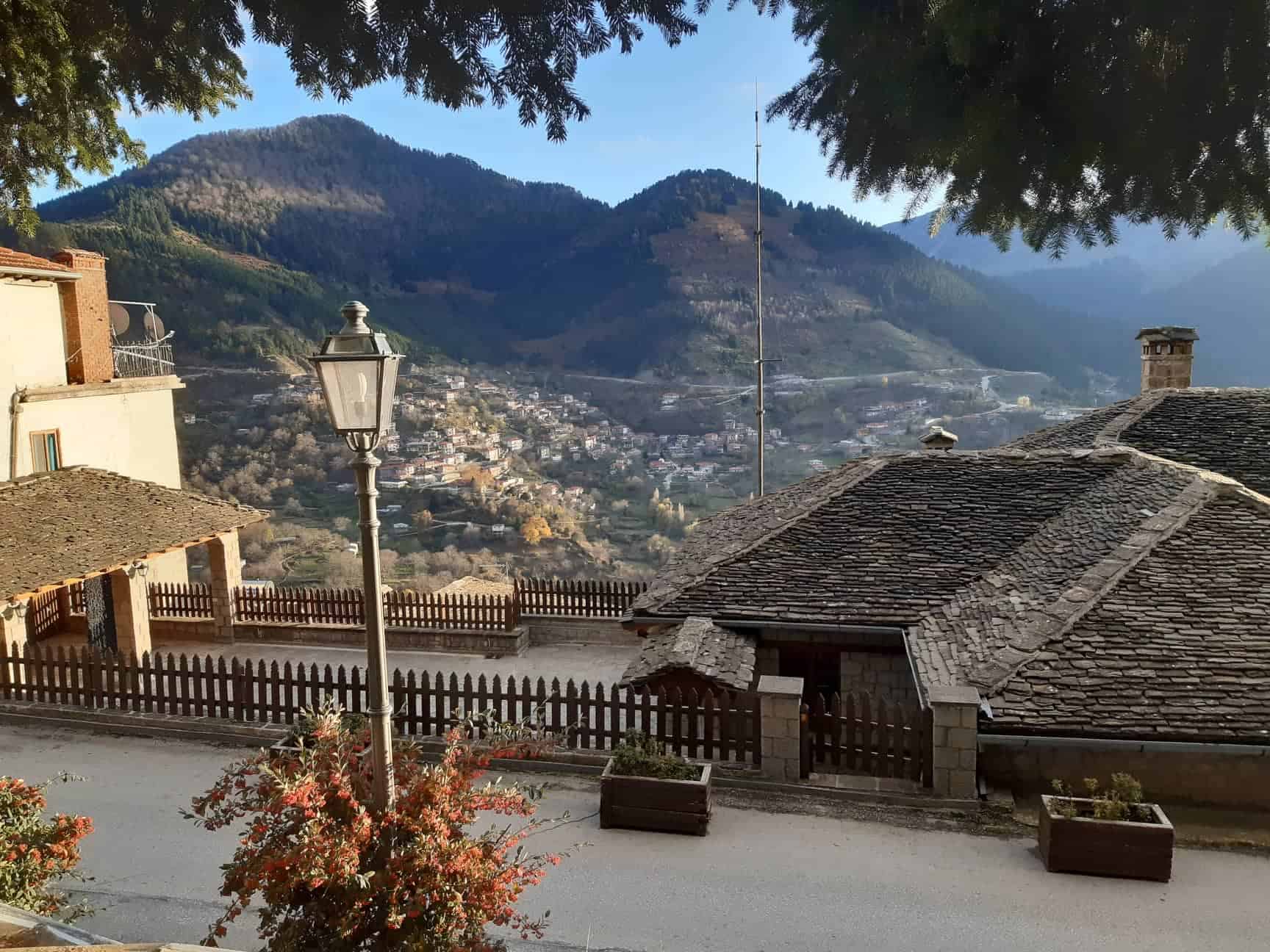 A scenic view of a tranquil village surrounded by majestic mountains