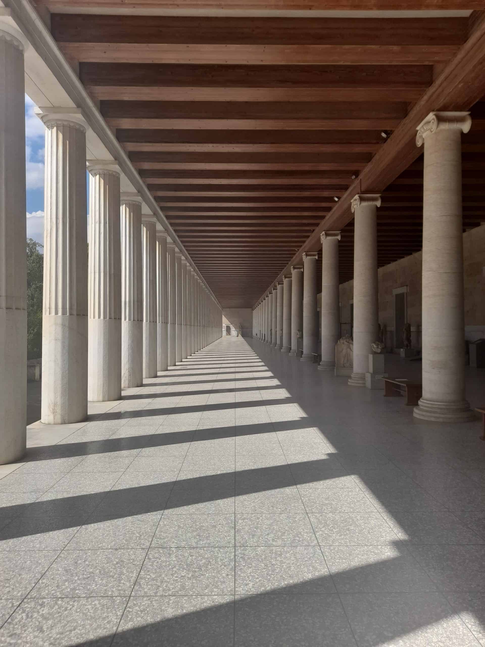 A sunlit walkway lined with elegant columns