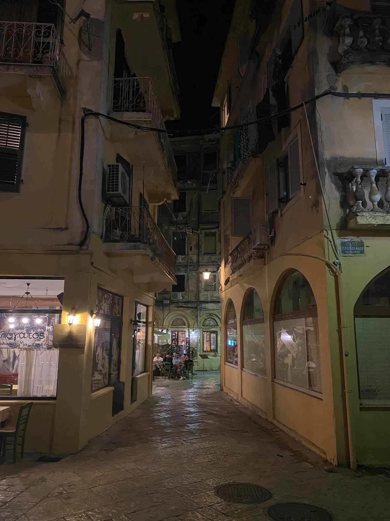 A narrow street illuminated at night