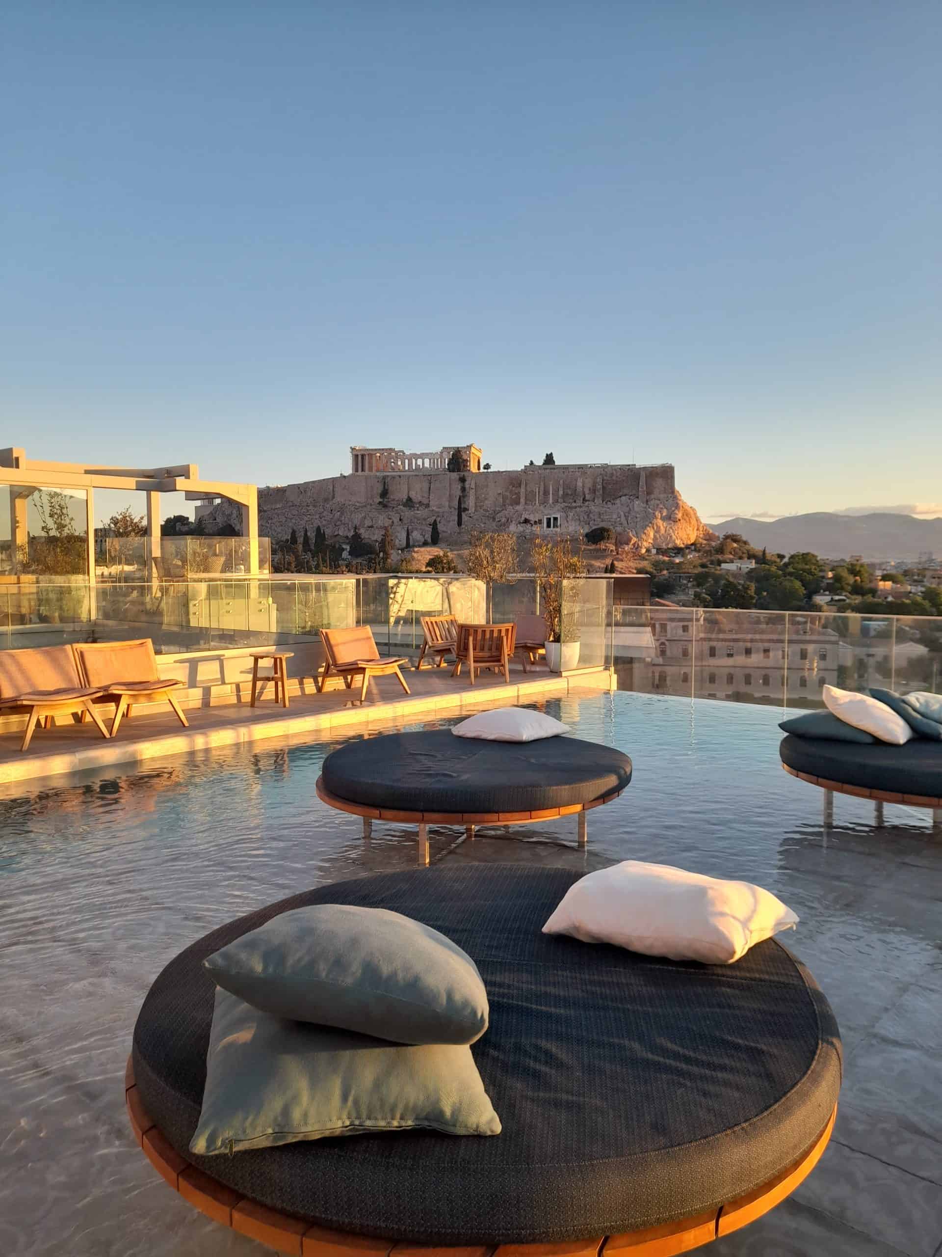 A serene hotel pool framed by a stunning view of the Acropolis