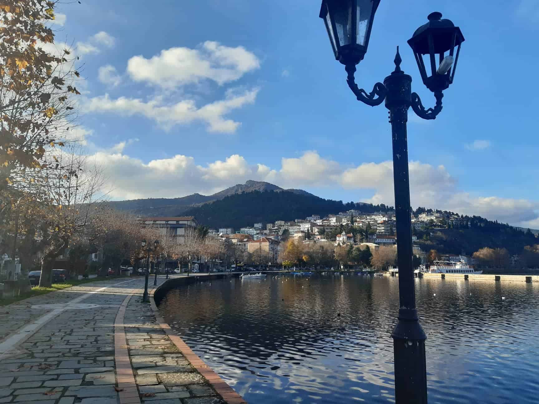 A street light stands beside a serene lake