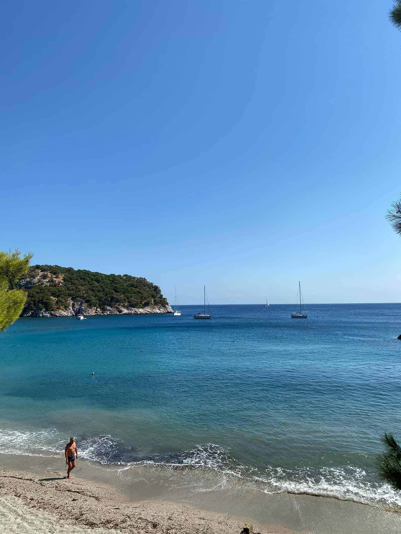 A person strolls along Stafylos beach