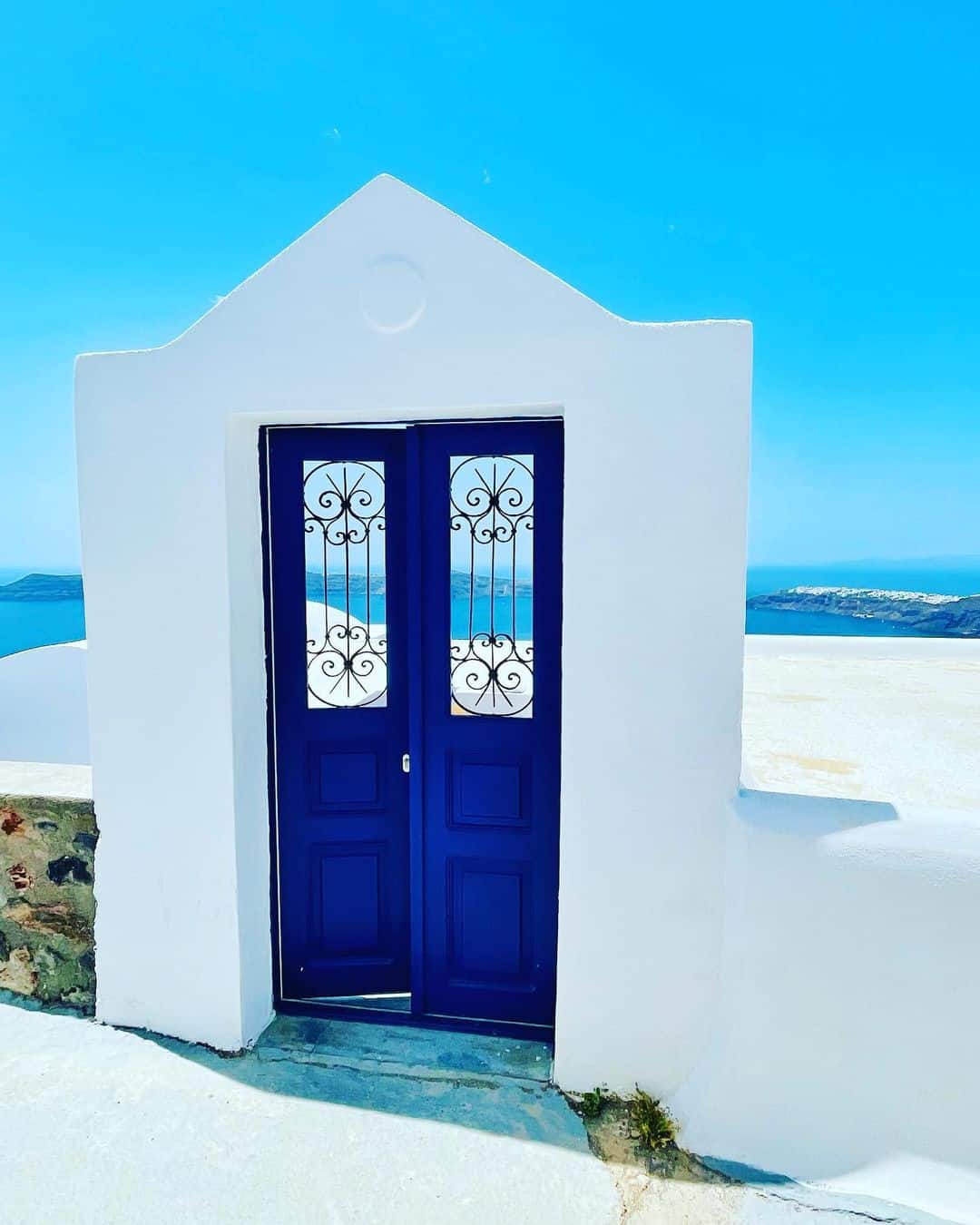 A vibrant blue door set against the whitewashed walls of a Santorini building