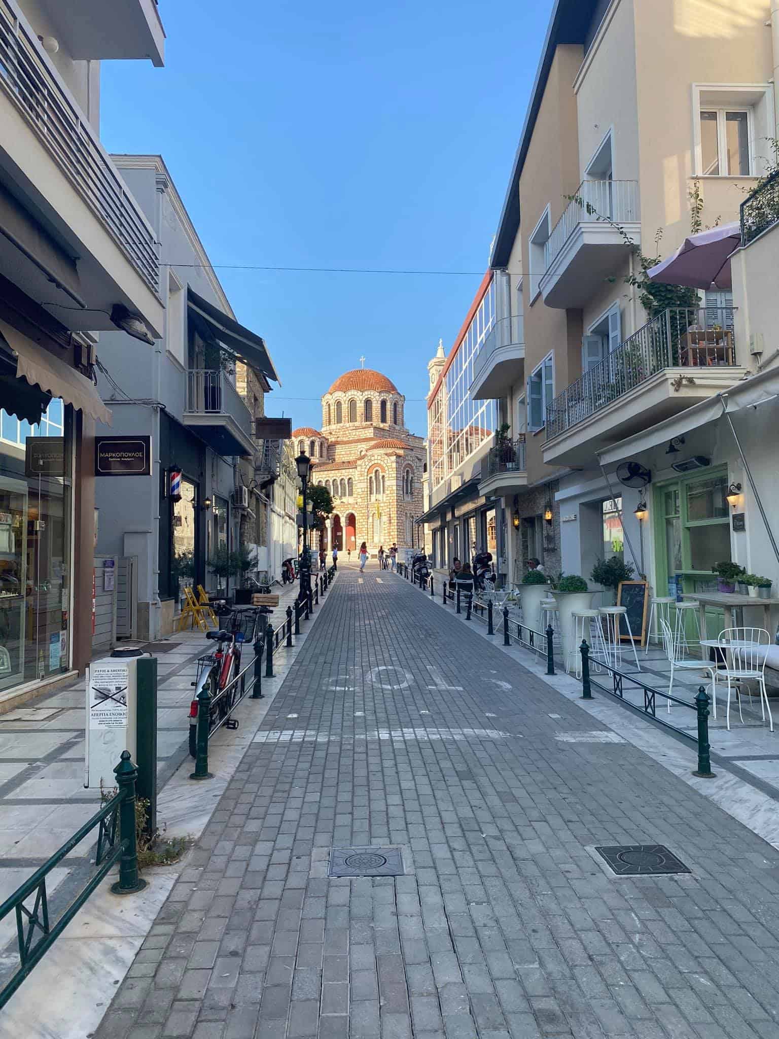 A lively urban street featuring various shops and buildings