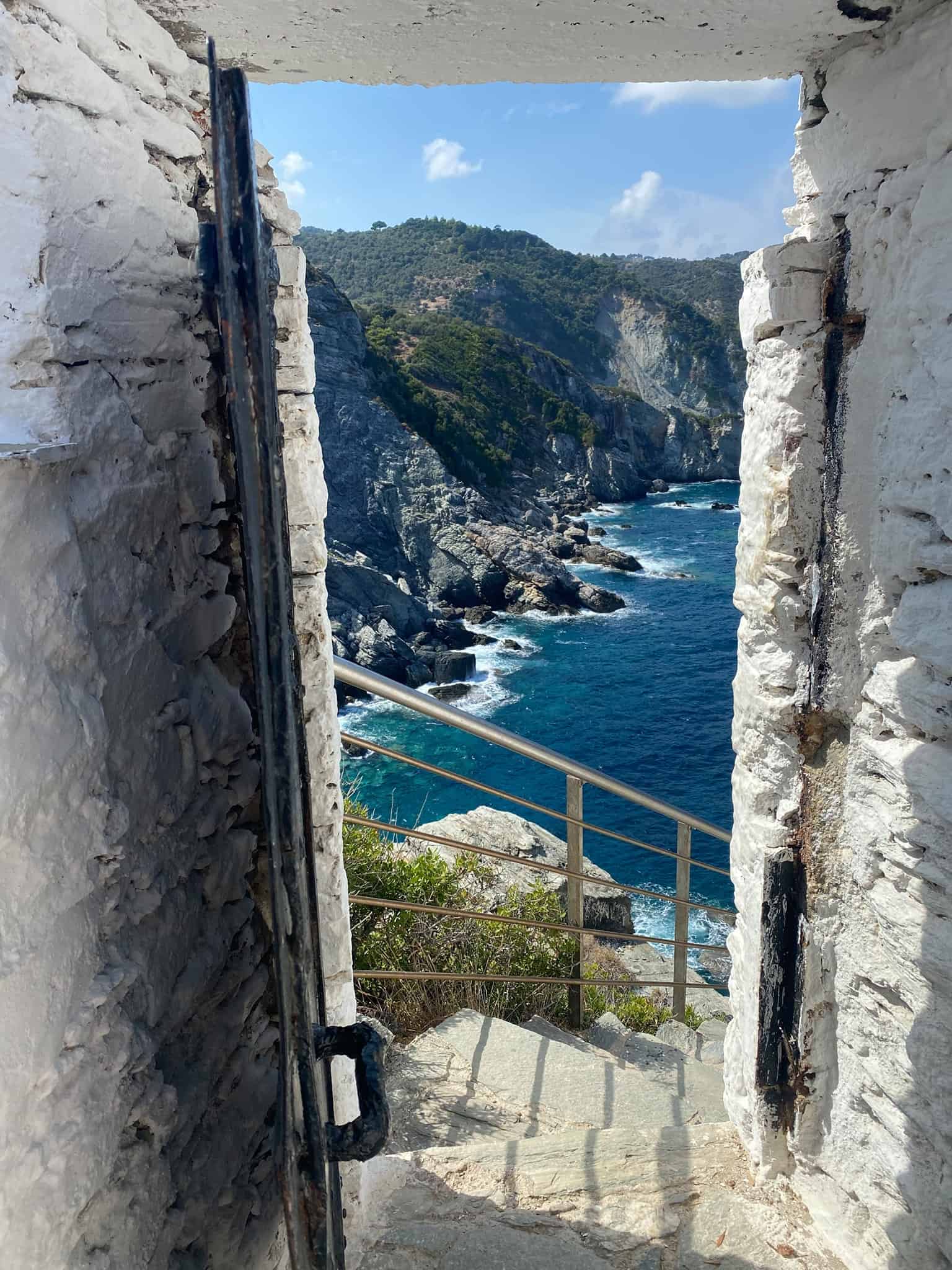 A serene view of the sea visible through an open door