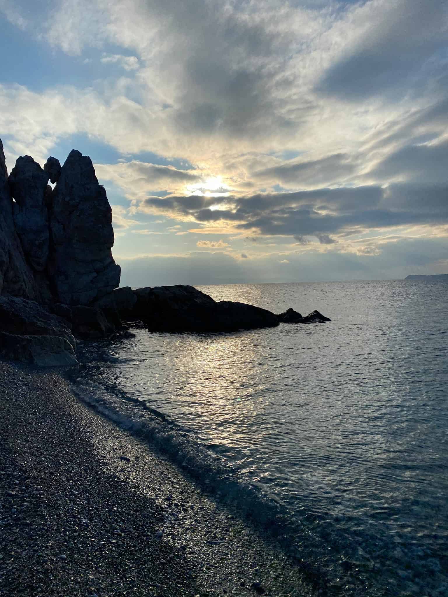 A serene sunset casts warm hues over the ocean