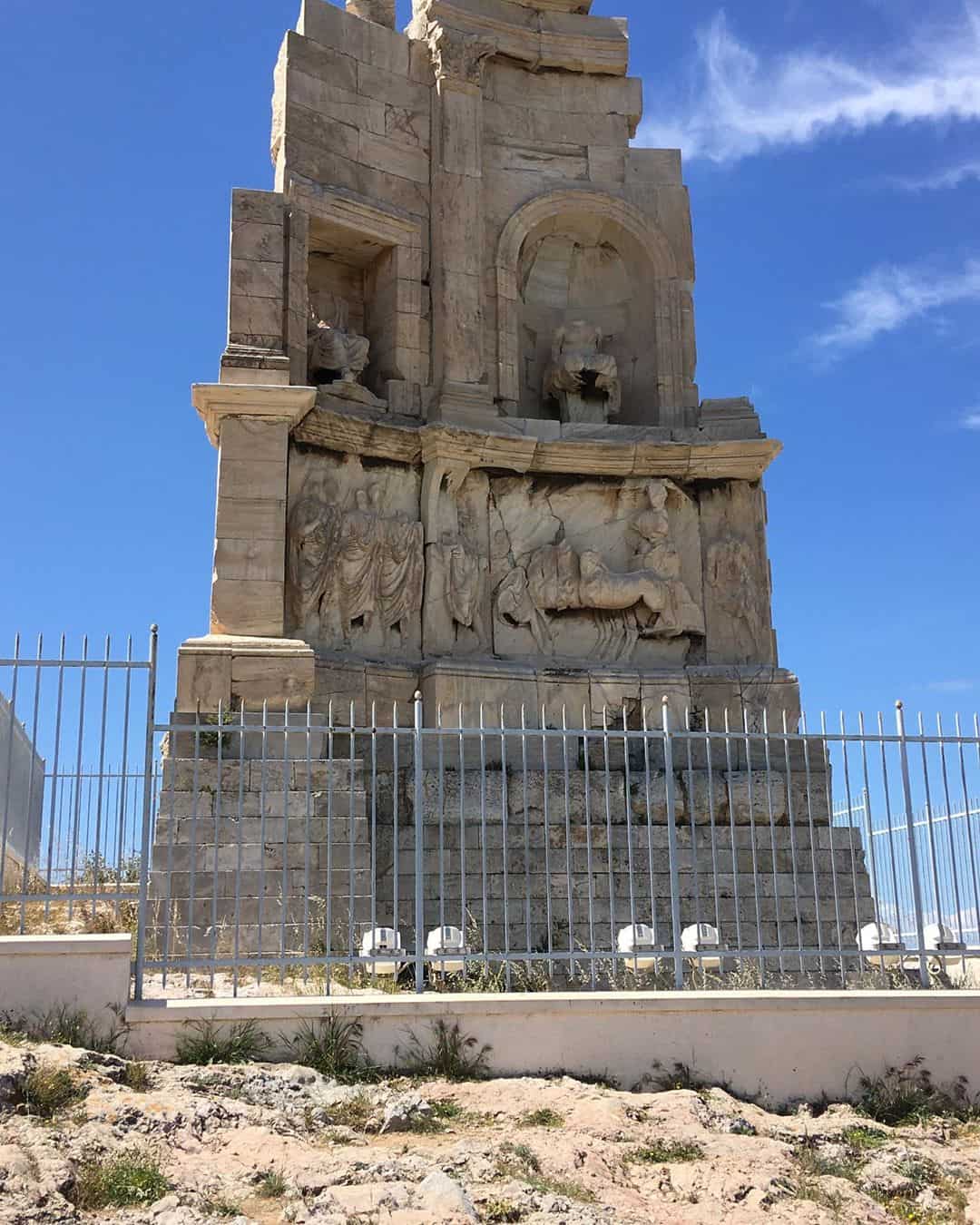 A stone monument enclosed by a fence