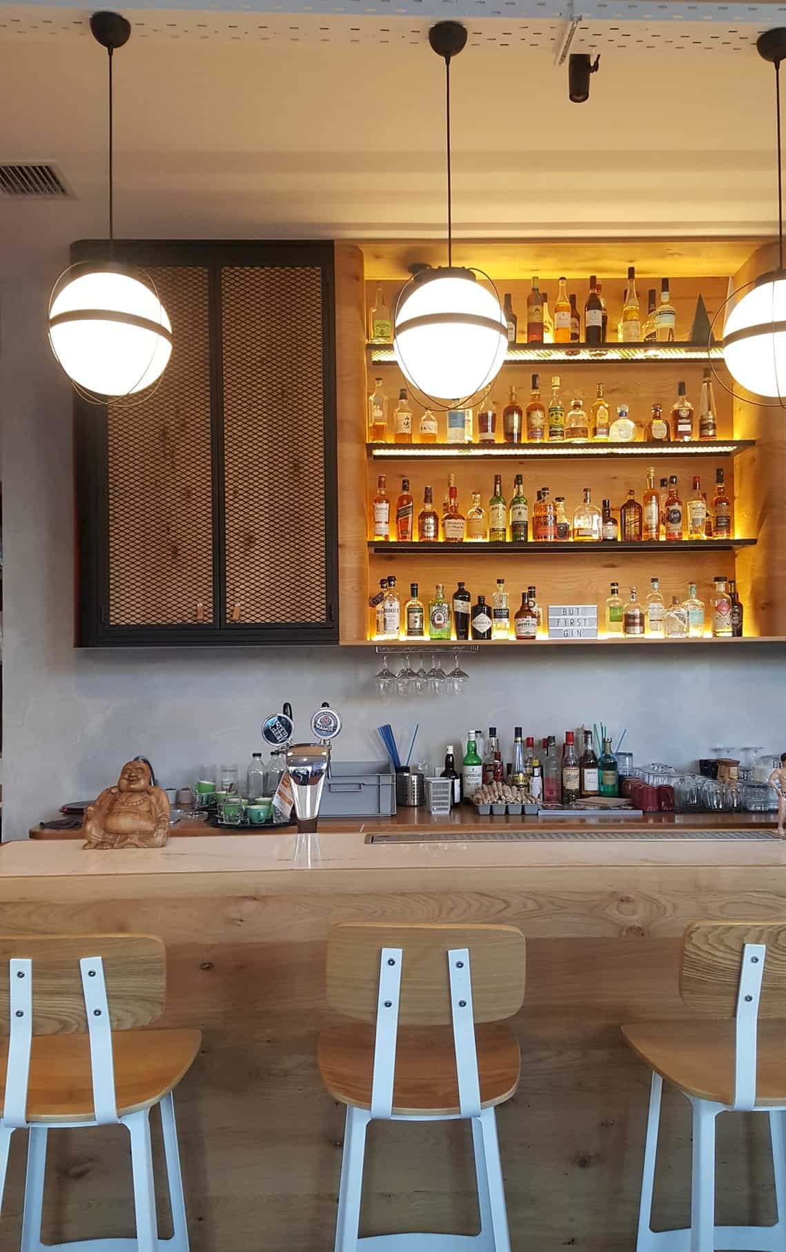 A rustic bar with a wooden counter and a selection of stools