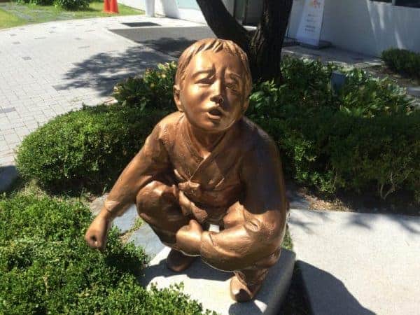 A stone statue depicting a boy sitting