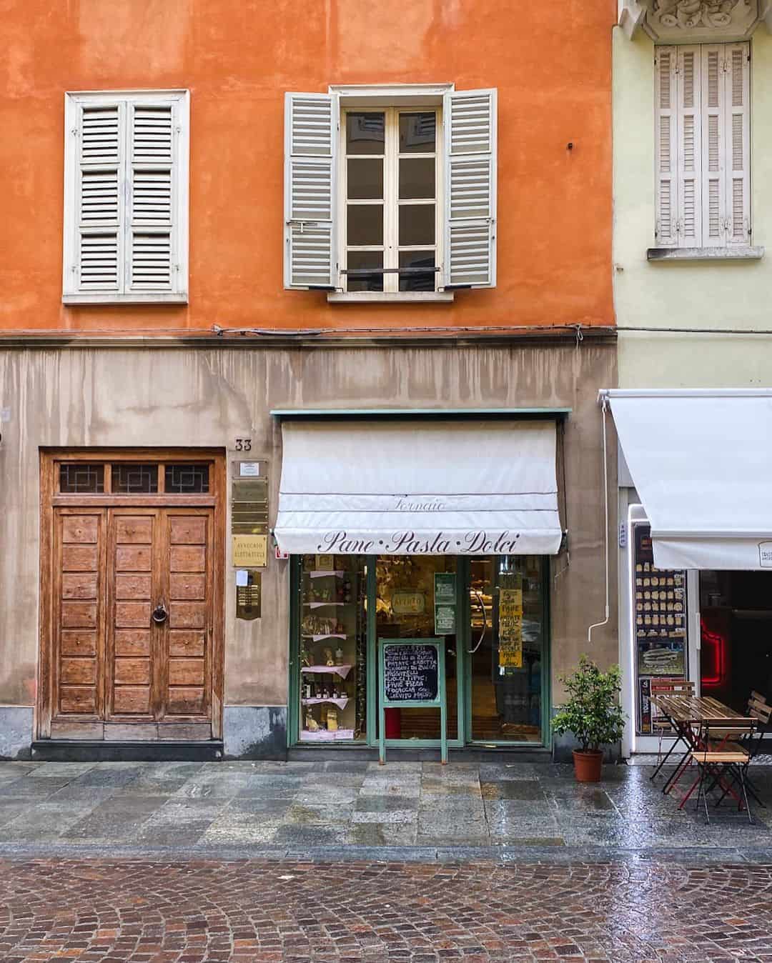 A charming street scene featuring a cafe and a building adorned with decorative shutters