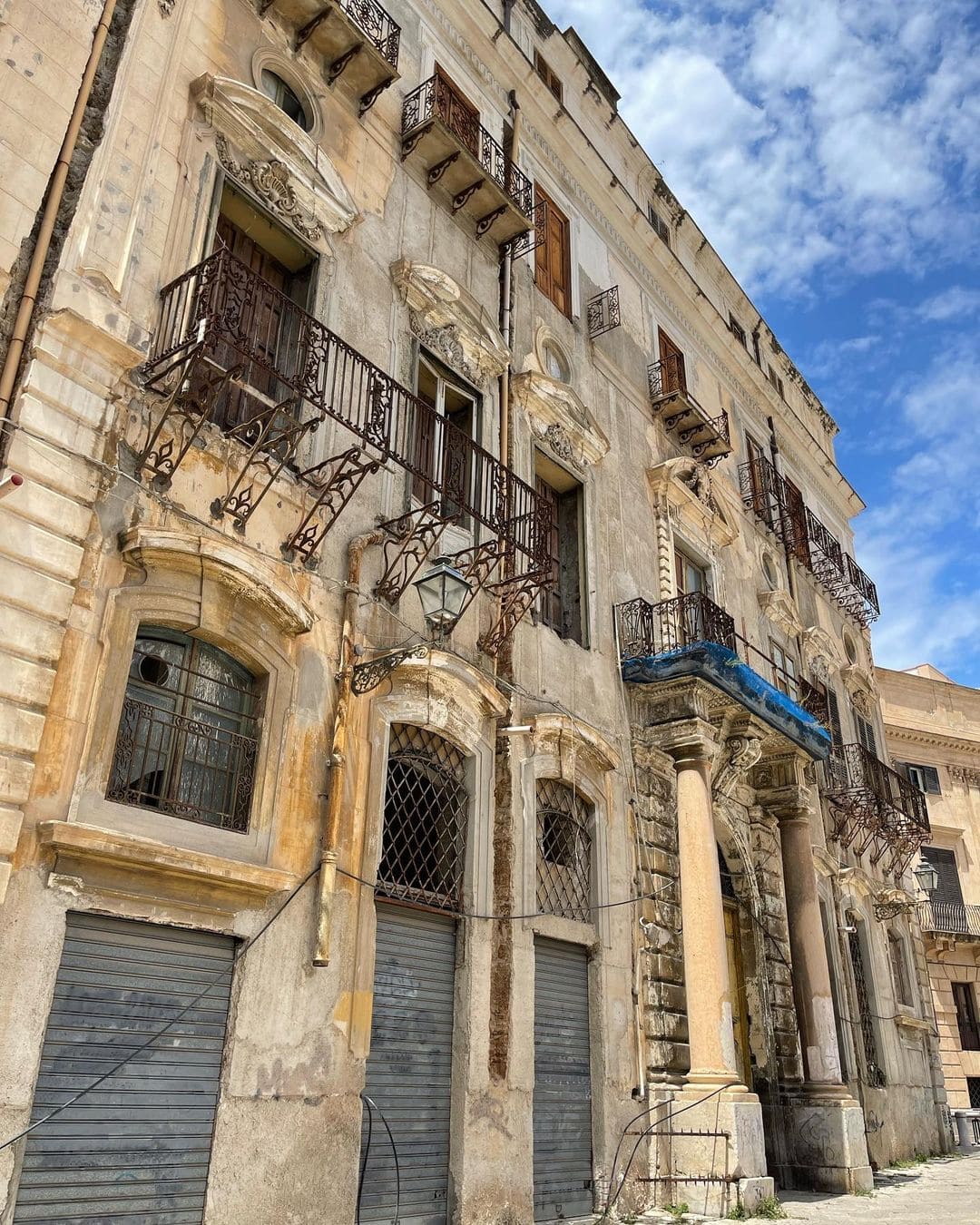 An old building featuring multiple balconies on its sides, showcasing classic architectural design and historical charm