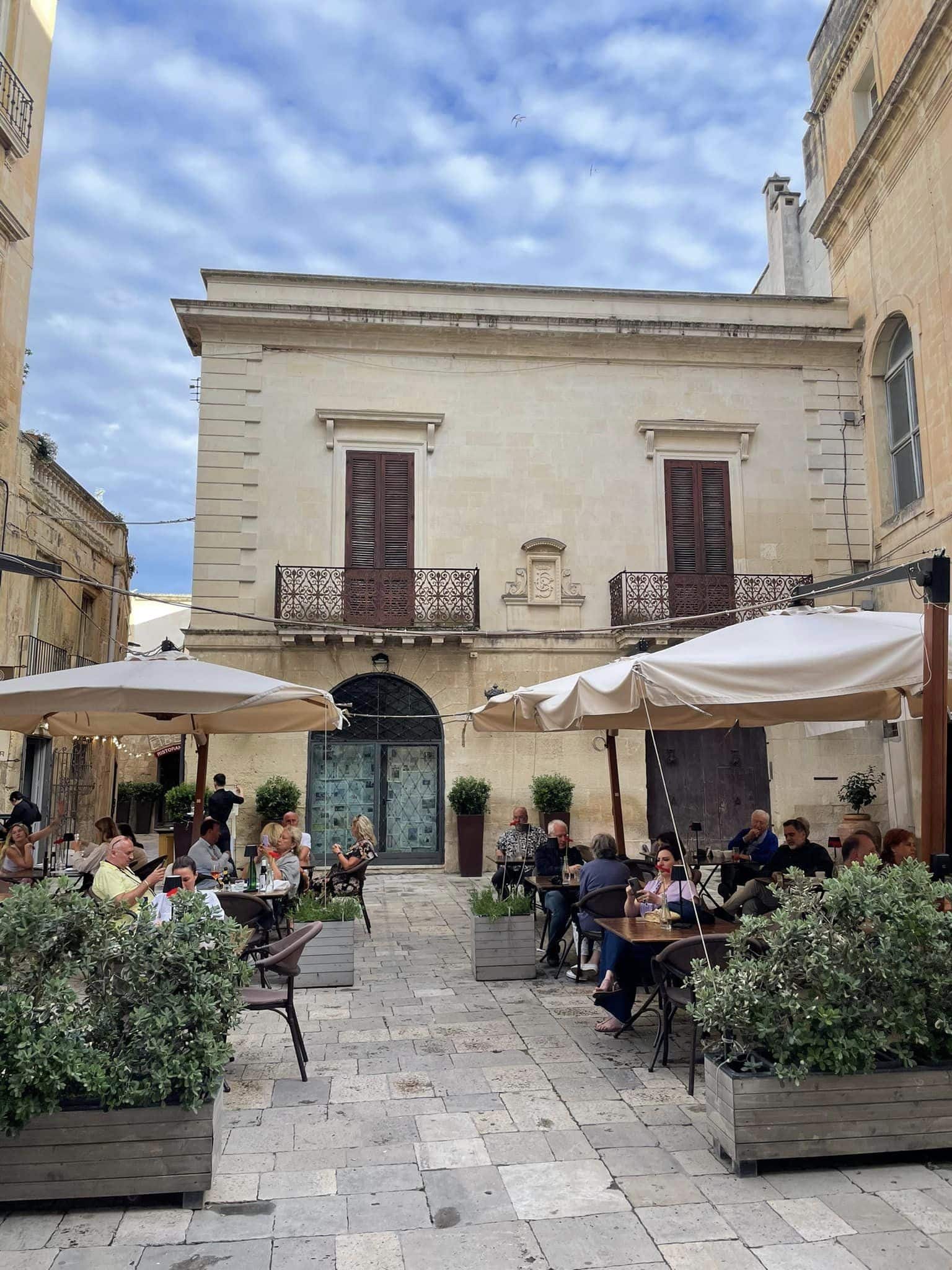 A vibrant outdoor courtyard filled with people seated at tables