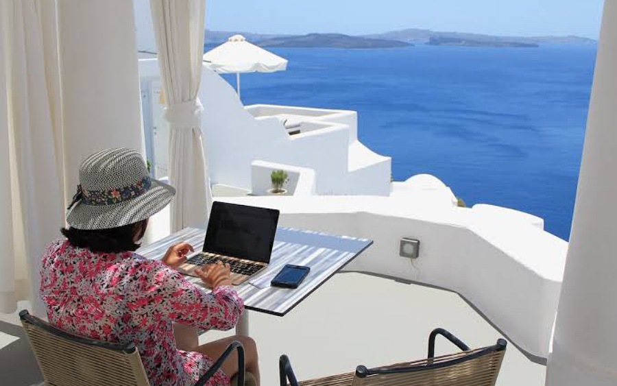 A woman seated at a table with a laptop