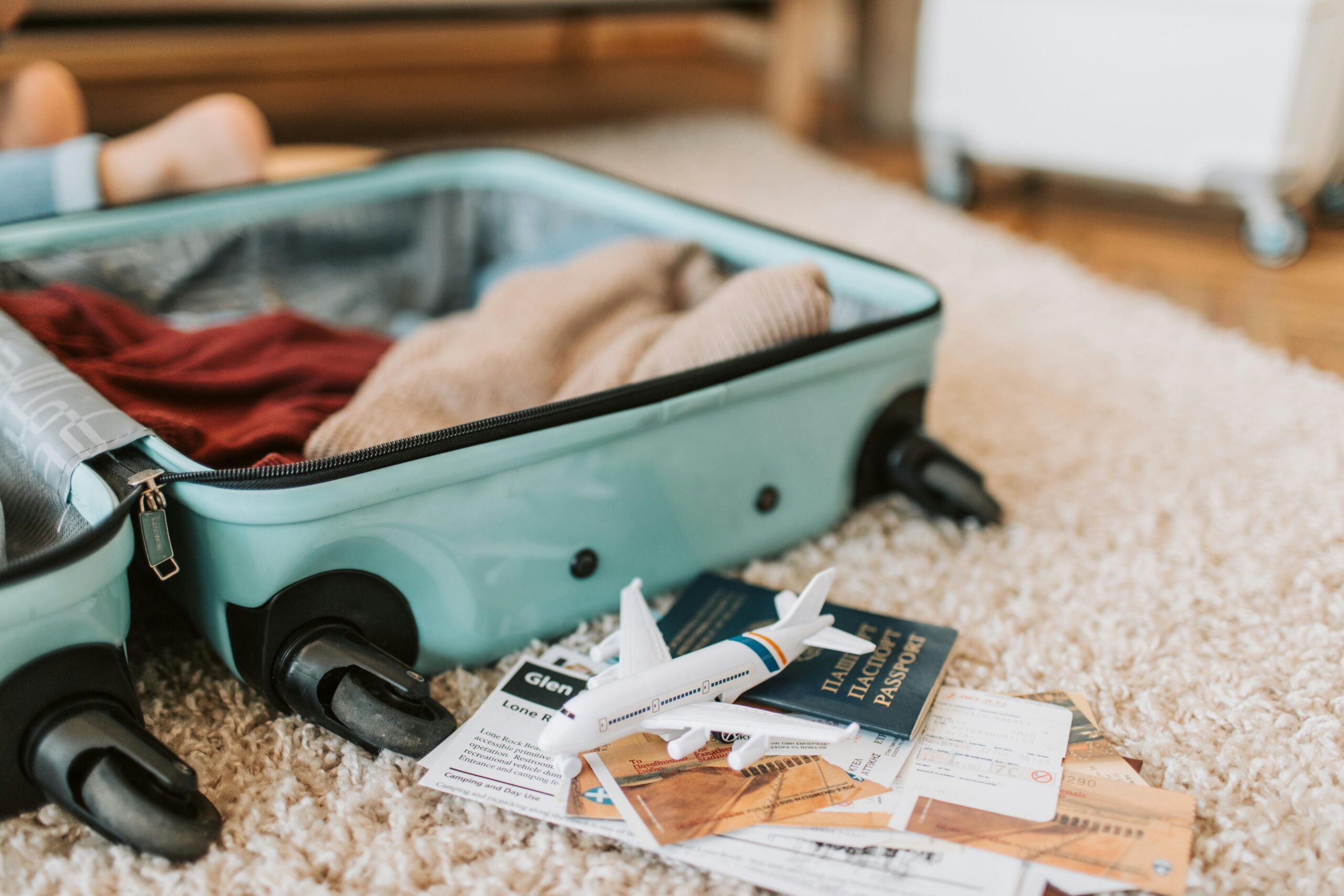 Travel-themed suitcase with miniature plane and passport