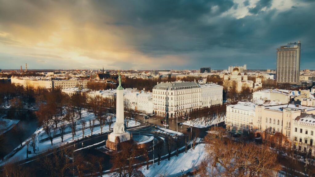 A breathtaking aerial shot of Rīga, Latvia in winter, showcasing the Freedom Monument and surrounding architecture.