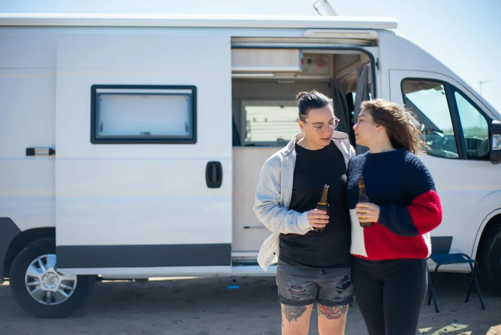 A couple enjoying a drink in front of an RV