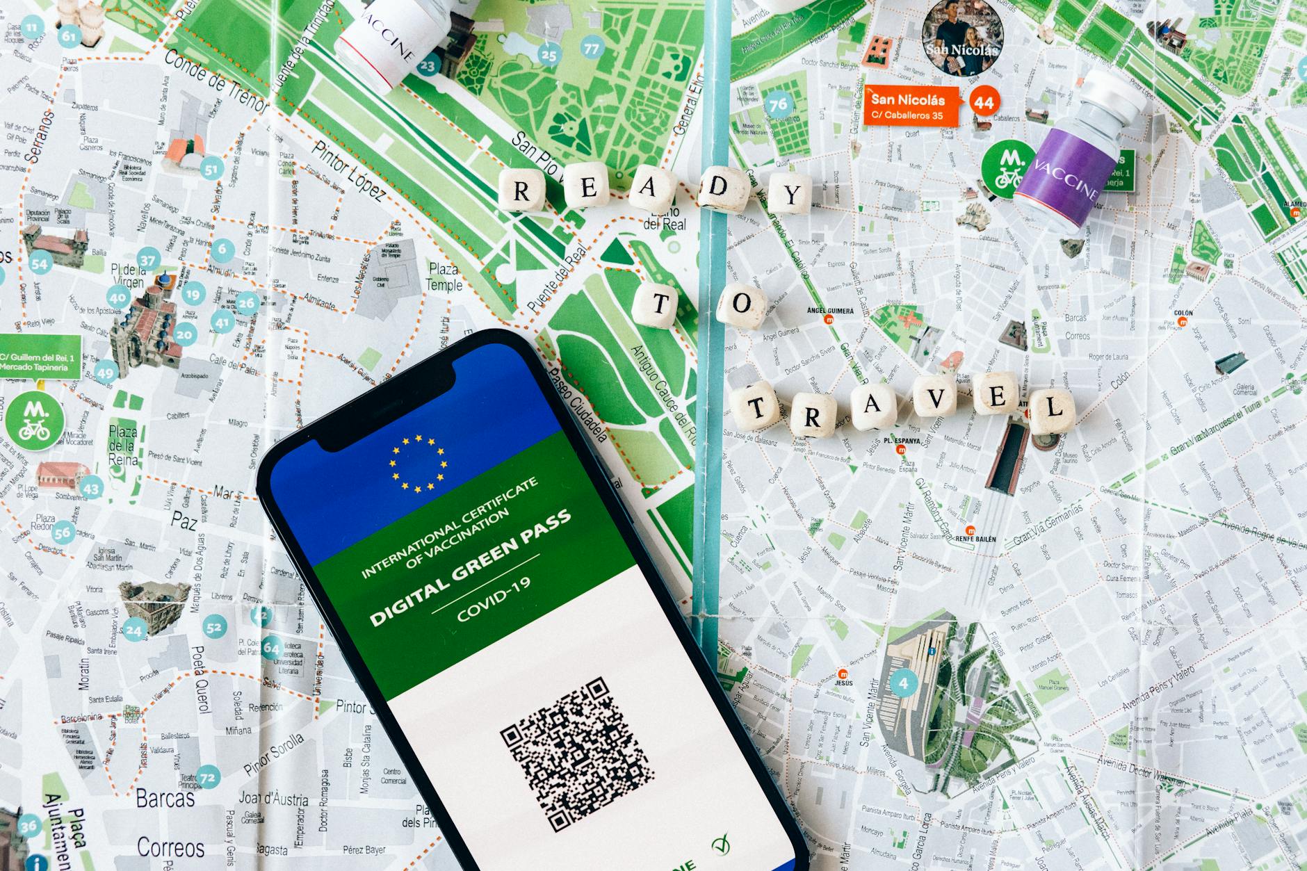 Digital Green Pass displayed on a phone with map background, illustrating travel planning and documentation