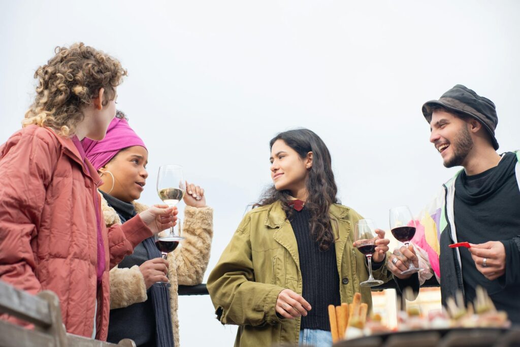 Friends enjoying wine outdoors in Portugal, sharing laughter and conversation, surrounded by a relaxed, scenic atmosphere.