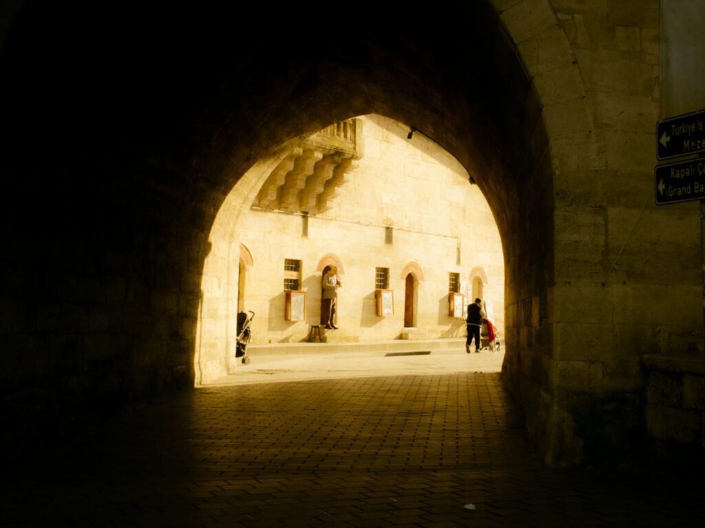 Historic archway in Istanbul lit by warm golden sunlight, showcasing intricate architectural details