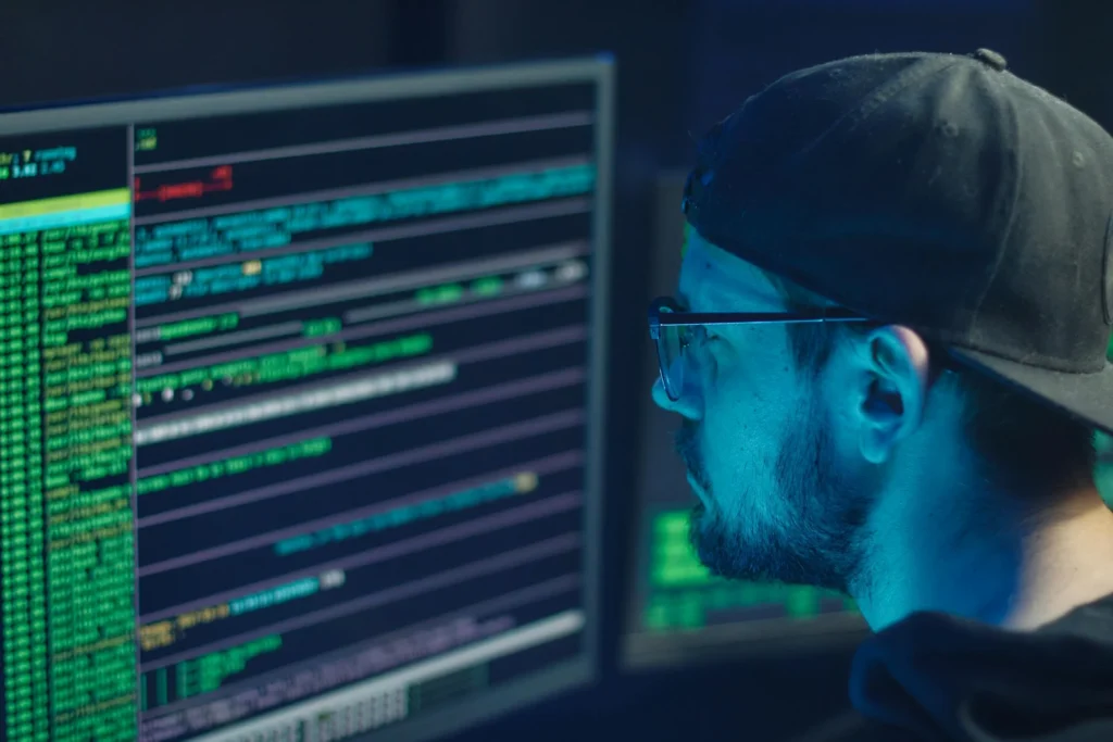 Tech professional analyzing code on multiple monitors, highlighting cybersecurity and data programming