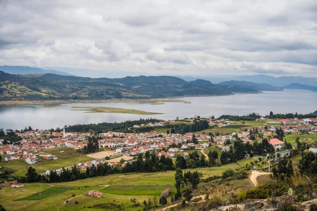 Aerial view of Guatavita town and lagoon surrounded by lush countryside.