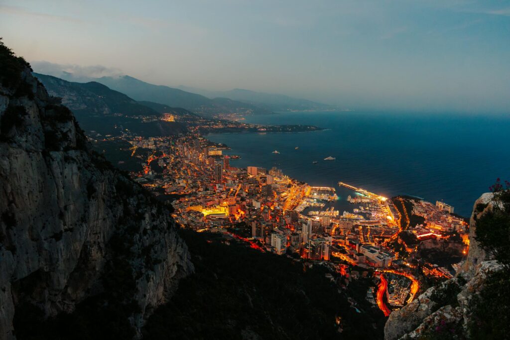 Stunning aerial perspective of Monaco's illuminated harbor and cityscape at twilight.