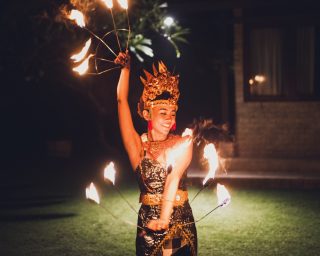 Balinese traditional dancing with fire show at evening beach party